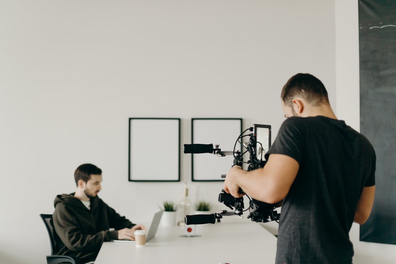 A videographer captures a focused professional working on a laptop in a stylish home office setting.